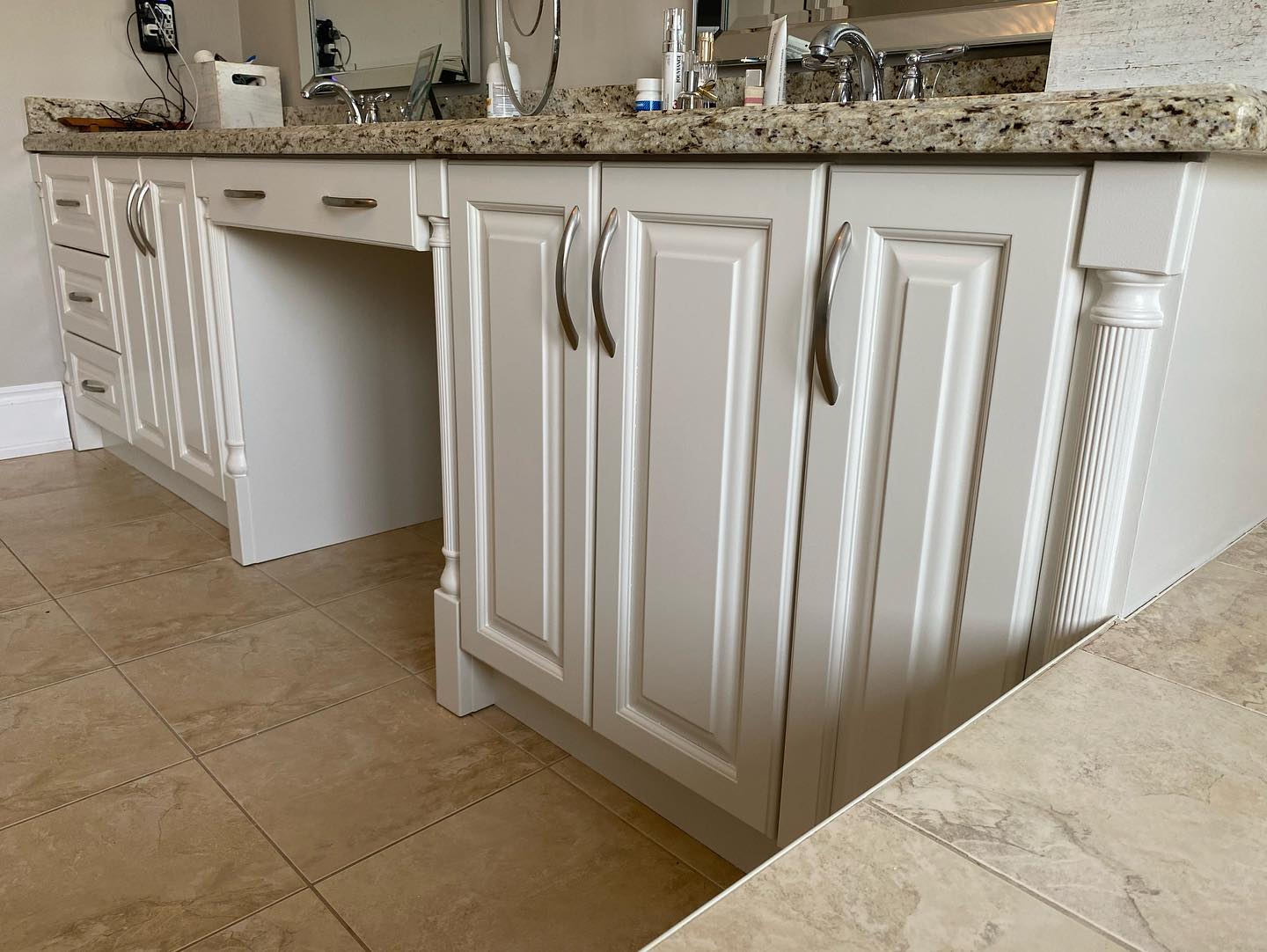 Finished off white vanity with raised panel doors and a desk space