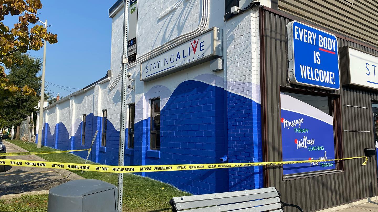 Commercial building side wall repainted blue and white with caution tape