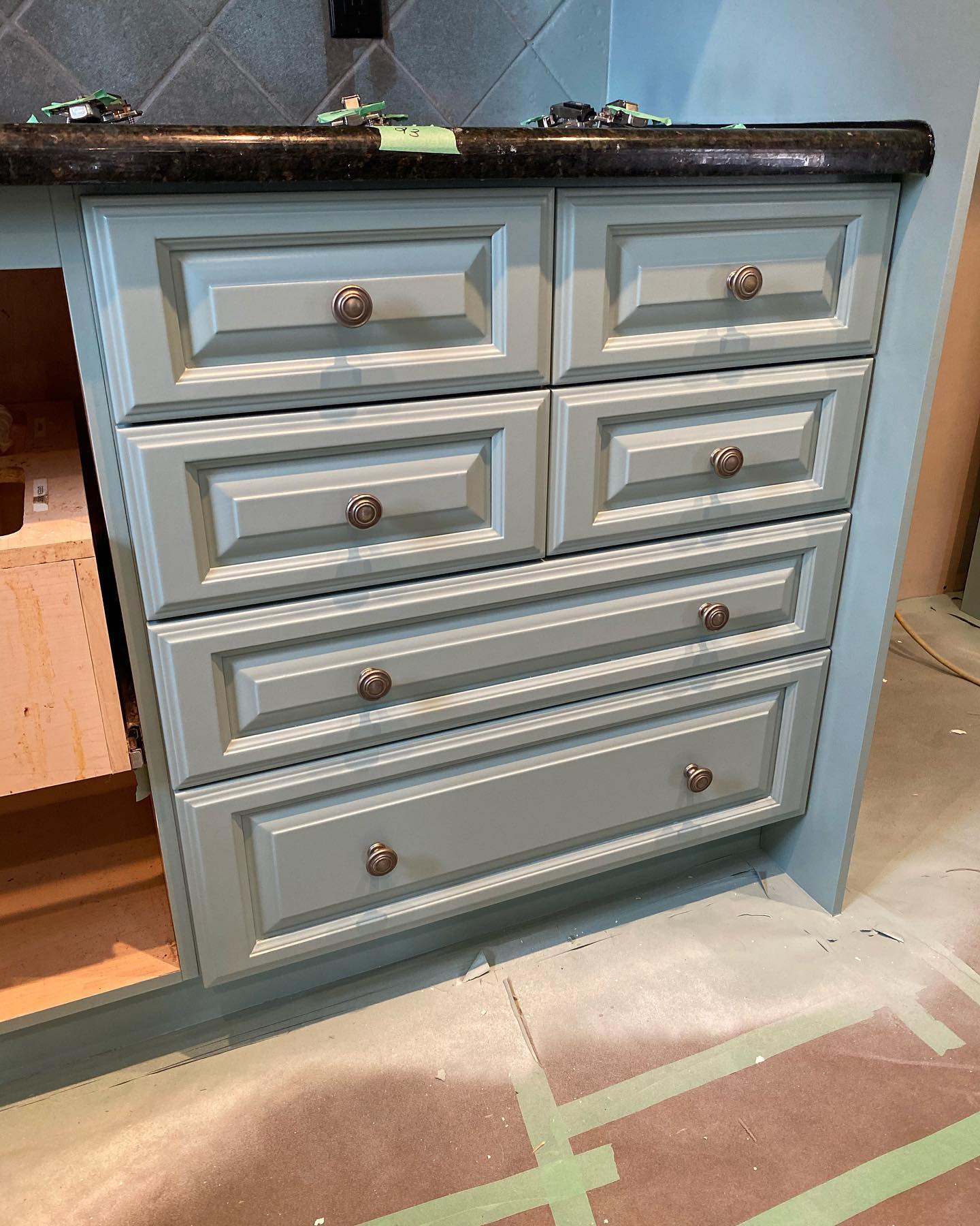 Grey-blue cabinet drawer fronts with floor masked